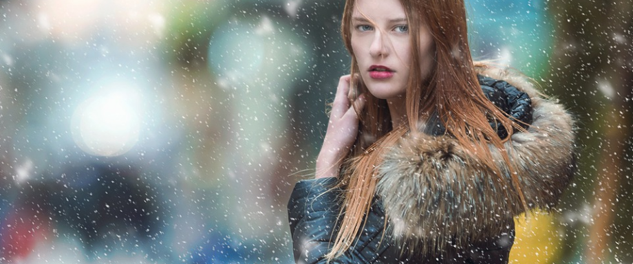 a woman standing outdoors during the snow